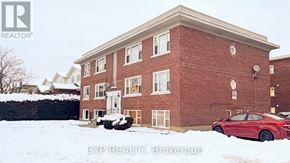 Ottawa multi-family for rent - A red car is parked in front of a brick building.