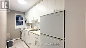 Ottawa multi-family for rent - A kitchen with white appliances and cabinets.