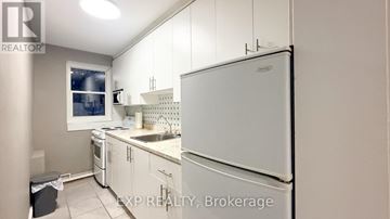 Ottawa multi-family for rent - A kitchen with white appliances and cabinets.