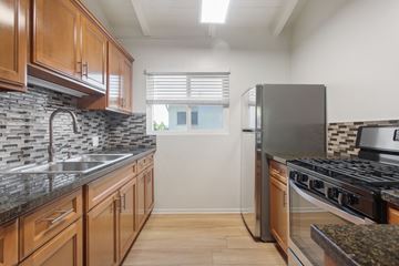 Pacific Palisades apartment for rent - A kitchen with wooden cabinets and a black stove top oven.