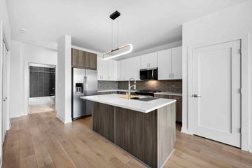 Villa Park apartment for rent - A modern kitchen with a white island and wooden floors.