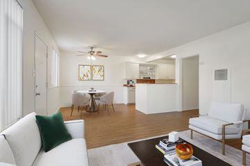 Santa Monica apartment for rent - A living room with a white couch and a coffee table with books and an apple on it.