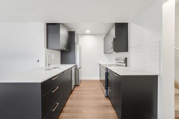 Edmonton apartment for rent - A modern kitchen with black cabinets and a white countertop.