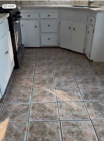 South Gate apartment for rent - A kitchen with white cabinets and a black stove top oven.