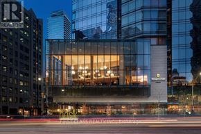 Toronto (Bay Street Corridor) condo for rent - A modern building with a glass facade and a sign that reads "First Class Realty Inc.".