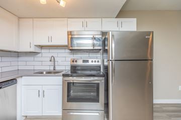 Phoenix apartment for rent - A modern kitchen with a stainless steel refrigerator, oven, and microwave.