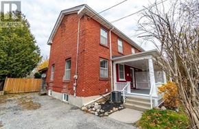 Cobourg house for rent - A red brick house with a white porch.