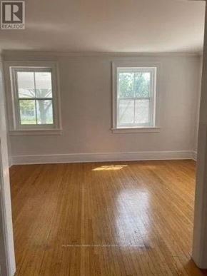 Cobourg house for rent - A room with wooden flooring and two windows.