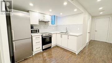 Markham (Berczy) house for rent - A kitchen with white cabinets and a stainless steel refrigerator.