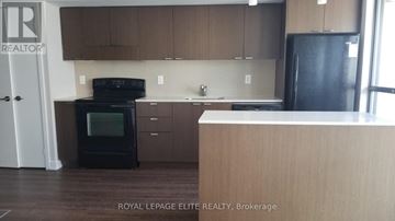 Toronto (Church-Yonge Corridor) condo for rent - A kitchen with brown cabinets and a black fridge.