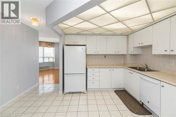 Stoney Creek condo for rent - A kitchen with white cabinets and a white fridge.