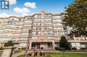 Stoney Creek condo for rent - A large, multi-story building with a curved facade and a sign that reads "Grand" in front of it.