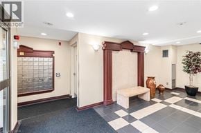 Stoney Creek condo for rent - A hallway with a bench and a potted plant.