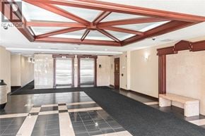 Stoney Creek condo for rent - A hallway with a checkered floor and a bench.