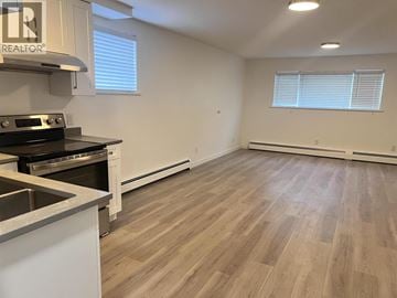 North Vancouver house for rent - A kitchen with a stove top oven and a sink.