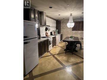 Burnaby house for rent - A modern kitchen with a table and chairs.