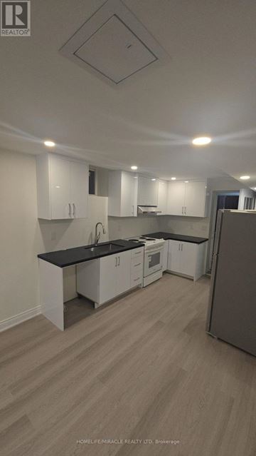 Brampton (Northwest Brampton) house for rent - A kitchen with white cabinets and a black countertop.