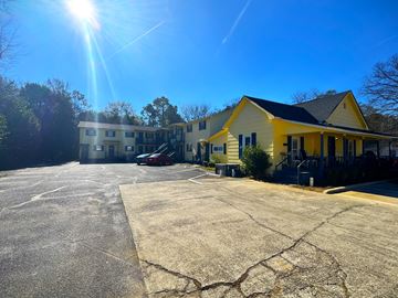 Fort Valley apartment for rent - A yellow building with a parking lot in front of it.