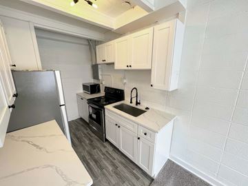 Salt Lake City apartment for rent - A kitchen with white cabinets and a black refrigerator.