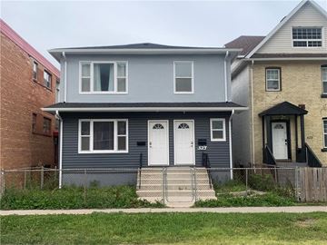 Winnipeg apartment for rent - A grey house with a white door and a black railing.