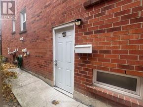 Mississauga (Creditview) house for rent - A red brick house with a white door and a small window on the side.