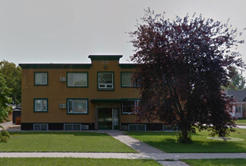 Winnipeg apartment for rent - A brown building with a tree in front of it.
