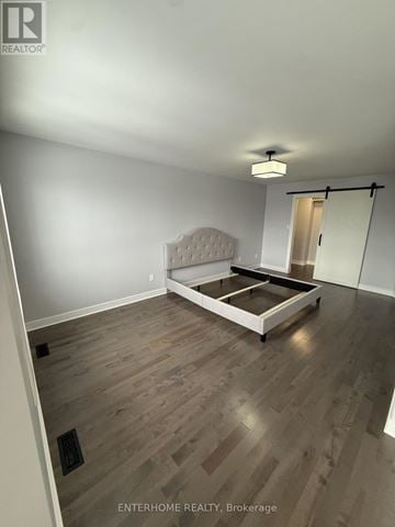 Barrie (East Bayfield) house for rent - A bedroom with a bed and a wooden floor.