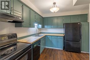 Thorold townhouse for rent - A hallway with a refrigerator on the left and a door at the end.