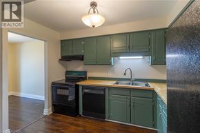 Thorold townhouse for rent - A kitchen with a black refrigerator and white cabinets.