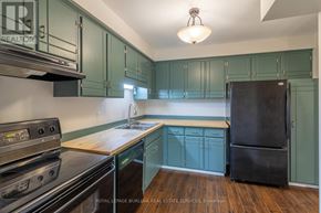 Thorold (Confederation Heights) townhouse for rent - A hallway with a refrigerator on the left and a door at the end.