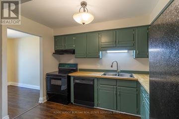 Thorold (Confederation Heights) townhouse for rent - A kitchen with a black refrigerator and white cabinets.