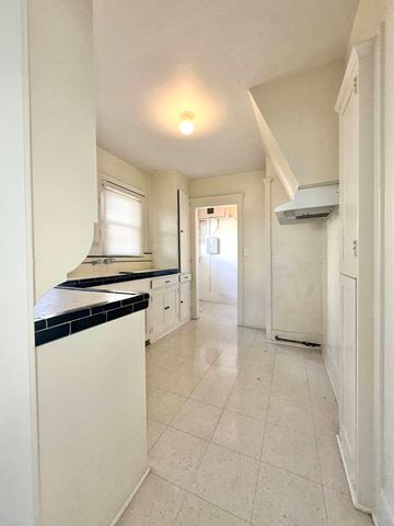 San Diego apartment for rent - A kitchen with white cabinets and a black counter top.