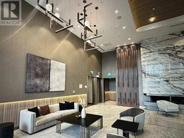 Toronto (York University Heights) condo for rent - A modern living room with a striped sofa and a marble fireplace.
