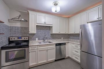 Durham apartment for rent - A kitchen with white cabinets and a stainless steel refrigerator.