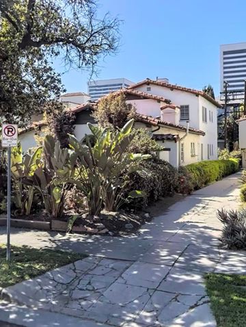 Los Angeles apartment for rent - A no parking sign is on a pole by a sidewalk.