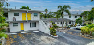 Oakland Park apartment for rent - A two-story house with yellow doors and a white exterior.