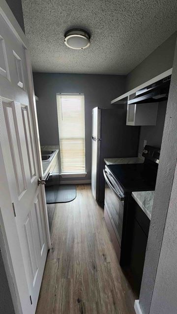 Killeen apartment for rent - A kitchen with a refrigerator, oven, and sink.
