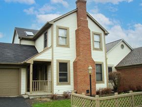 Reynoldsburg triplex for rent - a white house with a brick chimney and a wooden fence