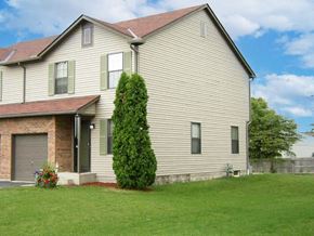Reynoldsburg triplex for rent - a white house with a garage and a green lawn
