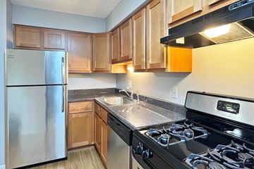 Forest Park apartment for rent - A kitchen with a stainless steel refrigerator and a black stove top oven.