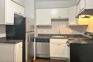 Forest Park apartment for rent - A kitchen with black appliances and white cabinets.