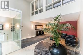 Ottawa condo for rent - A modern living room with a glass door and a large plant in a black pot.
