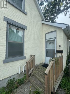 London North (North N) triplex for rent - A white house with a grey window and a wooden deck.