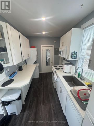 London North (North N) triplex for rent - A kitchen with white cabinets and a wooden floor.
