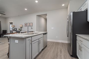 Georgetown apartment for rent - A kitchen with a black refrigerator and grey cabinets.