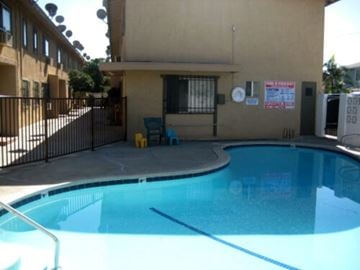 Downey apartment for rent - A small pool in a fenced in area outside a building.
