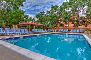 Denver apartment for rent - a swimming pool with blue chairs and a pavilion
