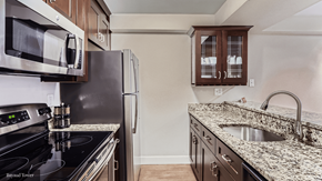 Denver apartment for rent - A kitchen with a black stove top oven and a black refrigerator.