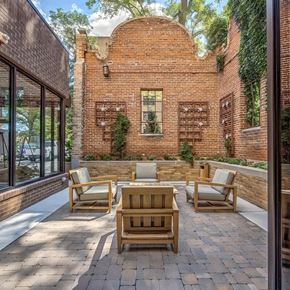 Denver apartment for rent - a patio with chairs and a table in front of a brick building
