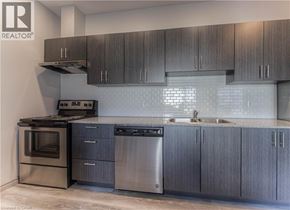 Waterloo condo for rent - A modern kitchen with dark wood cabinets and stainless steel appliances.